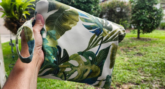 Hand holding a handmade cotton clutch bag with green tropical botanical leaves print outdoor by Luniquedesigns